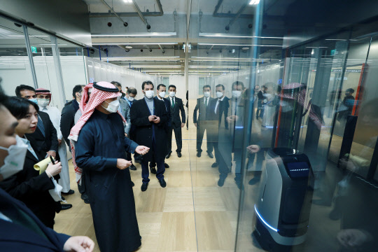 마제드 알 호가일 사우디아라비아 자치행정주택부 장관 일행이 29일 경기 성남 네이버 1784를 방문해 세계 최초의 로봇 전용 인프라 '로보포트'에 탑승한 자율주행로봇 '루키'에 대해 설명을 듣고 있다.    네이버 제공